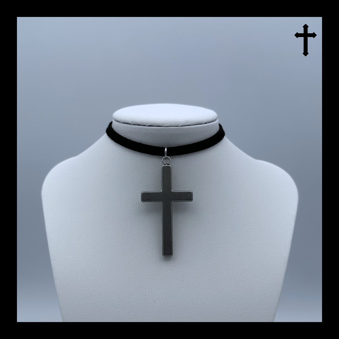 Black choker necklace with a silver cross pendant on a mannequin bust against a light gray background.